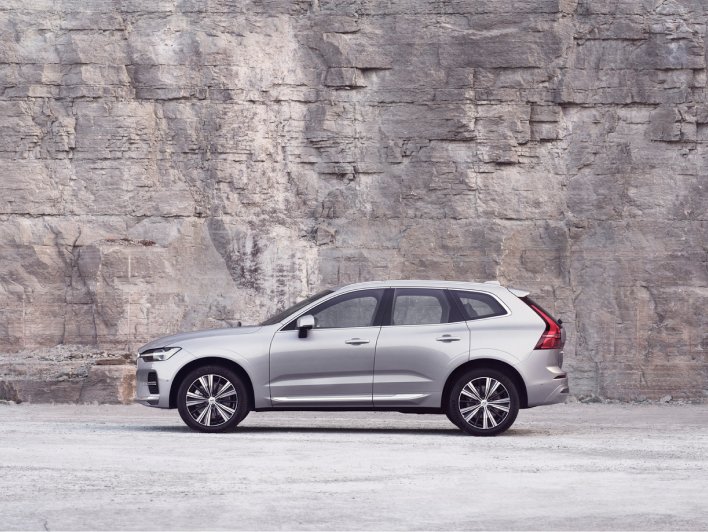 Image of XC60 in a concept location. The car is facing left. The background is a stone wall. The tonality is grey/pink-ish.